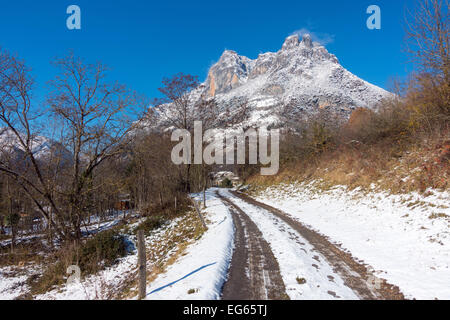 Snowy Track mit Reifenspuren in Richtung schneebedeckten Berg, Sinsat, Ariège, Französischen Pyrenäen, Frankreich Stockfoto