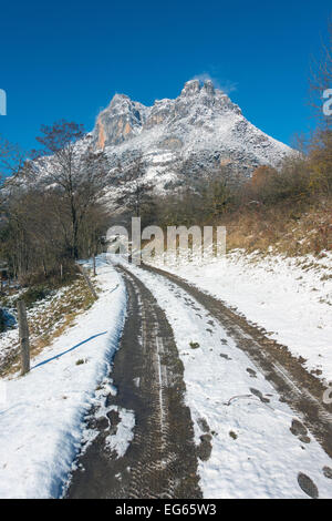 Snowy Track mit Reifenspuren in Richtung schneebedeckten Berg, Sinsat, Ariège, Französischen Pyrenäen, Frankreich Stockfoto