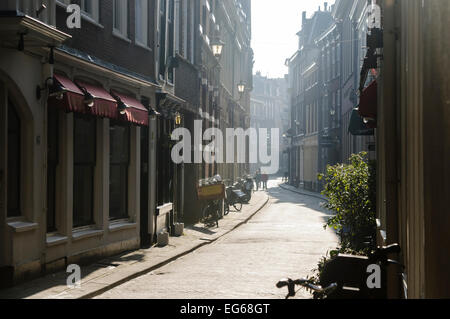 Die Menschen gehen entlang einer schmalen holländische Straße in den frühen Morgenstunden. Stockfoto