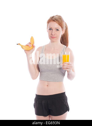 Sportliche Mädchen mit einer Banane und Saft in der Hand auf weißem Hintergrund. Stockfoto