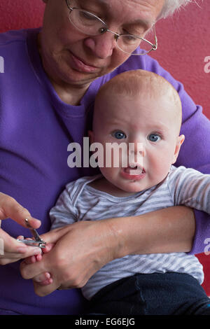 Denver, Colorado - sieben Monate alten Adam Hjermstad Jr. Schreie als seine Großmutter, Susan Newell, schneidet seine Fingernägel. Stockfoto