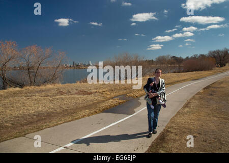 Denver, Colorado - eine Frau trägt ihr sieben Monate alte Sohn, wie sie läuft auf einem Trail um Sloan See. Stockfoto