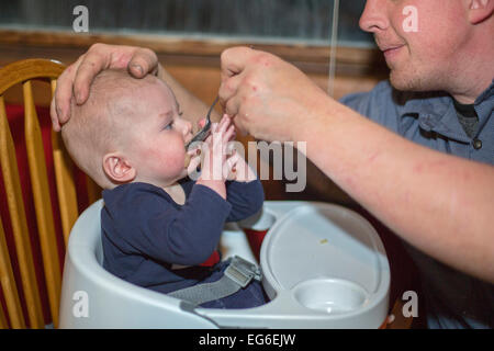 Denver, Colorado - Adam Hjermstad füttert seinen sieben Monate alten Sohn, Adam Hjermstad Jr Apfelmus. Stockfoto
