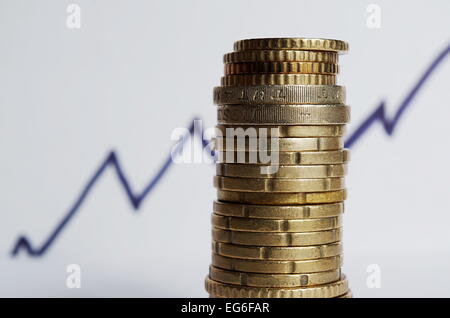 Stapel von Münzen mit einer steigenden Chart im Hintergrund. Wirtschaft und Finanzen Stockfoto
