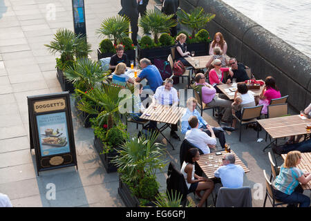 Menschen sitzen vor Doggetts Mantel & Abzeichen Pub an einem warmen Nachmittag auf der Southbank Stockfoto