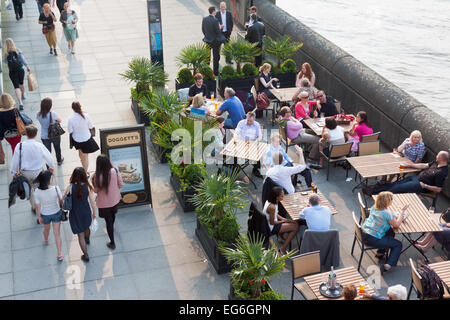 Menschen sitzen vor Doggetts Mantel & Abzeichen Pub an einem warmen Nachmittag auf der Southbank Stockfoto