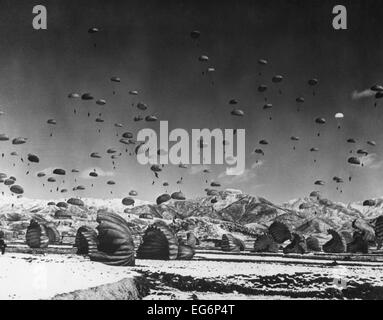 Männer und Ausrüstung als Fallschirm zur Erde in einer Operation unter der Leitung von Luftlandeeinheiten der Vereinten Nationen. Ca. 1951. Korea-Krieg Stockfoto