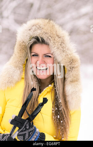 Blonde junge lächelnde Frau mit Ski im Winter. Fair kaukasische Mädchen viel Spaß beim Skifahren Stockfoto