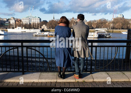 Zwei Personen blicken auf der Themse in Richtung Tempel, von der riverside Promenade am Südufer. London, UK. Stockfoto