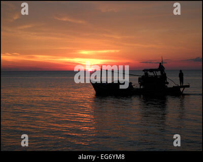 Ein Fischerboot in Long Beach, Phu Quoc, mit einem Sonnenuntergang im Hintergrund. Stockfoto