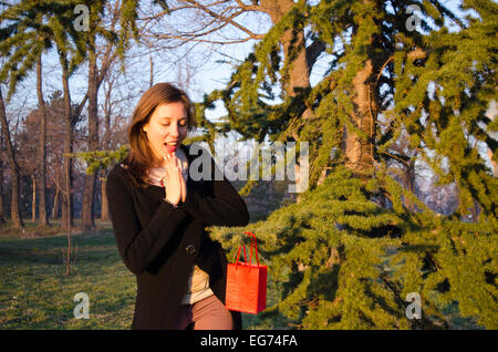 Brünette, die Suche nach ihr Valentinsgeschenk an einem Baum in einem park Stockfoto