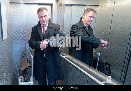 Vorsitzender der Union der deutschen Lokführer (GDL) Claus Weselsky steht in einem Aufzug und wirft einen Blick auf seine Uhr am Hauptsitz GDL in Frankfurt/Main, Deutschland, 18. Februar 2015. Nach Ablauf der ein Ultimatum bezüglich eines Tarif-Konflikts mit der Deutschen Bahn erläutert die Zug Fahrer Union GDL hier einen möglichen Streik. Foto: BORIS ROESSLER/dpa Stockfoto