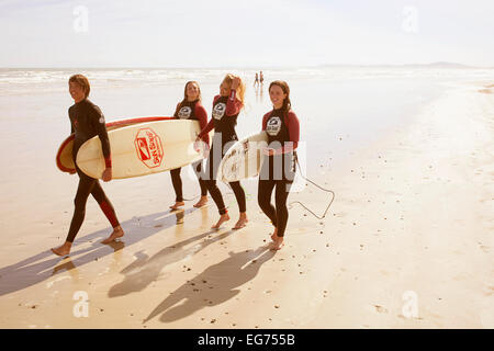 Junge glücklich Surfer zu Fuß den Strand mit Surfbrettern Stockfoto