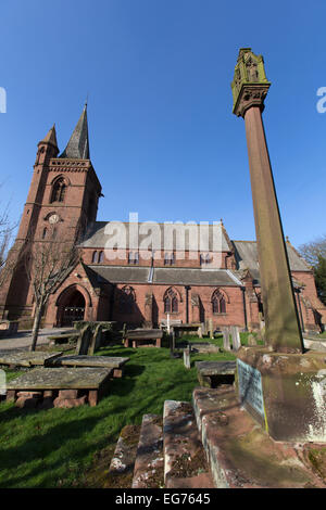 Dorf Aldford, England. Malerische Aussicht eines Denkmals Kreuz auf dem Gelände des St. Johannes der Täufer Kirche. Stockfoto