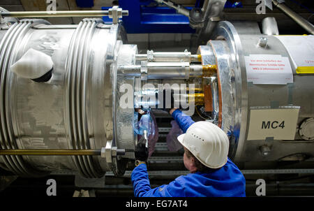 Hamburg, Deutschland. 18. Februar 2015. ILLUSTRATION - steuert ein Mitarbeiter eine Kupplung in den Beschleunigertunnel Partikel des X-Ray-Laser-Projektes European XFEL vorbei das Gaspedal (gelb) in Hamburg, Deutschland, 18. Februar 2015. Das Projekt umfasst ein 3, 4 Kilometer langen Tunnelsystem, in dem nach Fertigstellung Ende 2016, extrem kurzen und intensiven Röntgenblitze generiert werden sollen. Foto: DANIEL BOCKWOLDT/Dpa/Alamy Live News Stockfoto