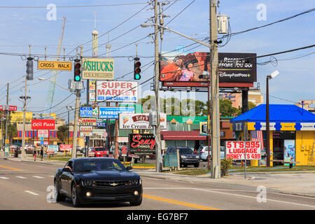 Chevrolet Sportwagen fahren am International Drive, Orlando, Florida vorbei an Reihen von Werbetafeln, Amerika. Stockfoto