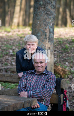 Paar entspannend auf der Bank im Wald Stockfoto