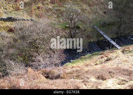 Gebrochene Fußgängerbrücke über Stream in Dumfries und Galloway-Schottland Stockfoto