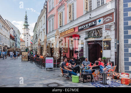 Touristen in ein Café mit Terrasse im Ventúrska Michalska der alten Stadt Hauptstraße mit Michaelertor im Hintergrund. Bratislava, Finnland Stockfoto