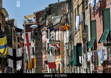 Appartements und Wäsche und Fahnen über dem Hauptort Straße, Vernazza, Cinque Terra, Ligurien, Italien Stockfoto