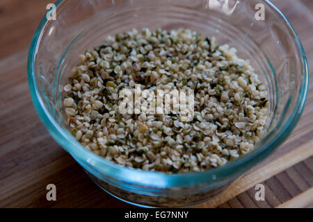 Hanfsamen in eine Glasschüssel auf einem Bambus-Schneidebrett. Hanfsamen sind eine große Quelle von Protein. Stockfoto