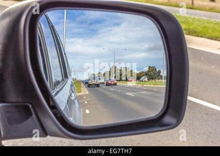 Fahrzeuge fahren auf Autobahn durch Rückspiegel gesehen. Stockfoto