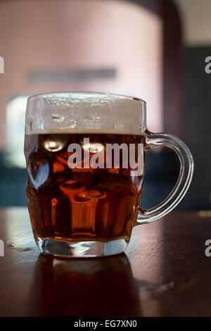 Pint Bier in einem traditionellen Grübchen Glas Krug Stockfoto