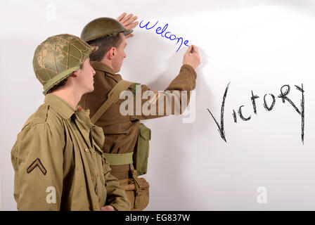 ein englischer Soldat und ein amerikanischer Soldat schreiben herzlich willkommen an der Wand Stockfoto