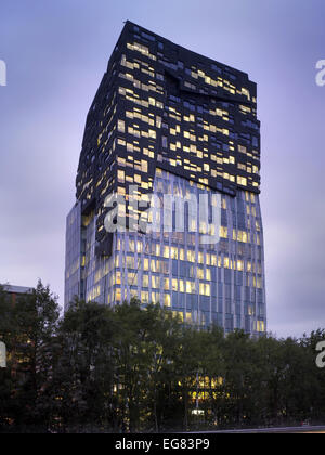 Der Felsen, Amsterdam, Niederlande. Architekt: Erick van Egeraat, 2011. Beleuchtete Gebäude in der Dämmerung. Stockfoto