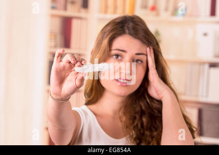 nervös junges Mädchen hält Schwangerschaftstest Stockfoto