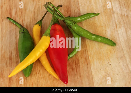 Bunte Chili - rot, grün, gelb - Holz-Hintergrund Stockfoto