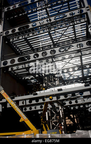 Hochreflektierende Stahlträger glänzen bei starker Sonneneinstrahlung auf eine South London Baustelle. Stockfoto