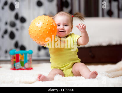 Kleinkind spielt mit Ball indoor Stockfoto