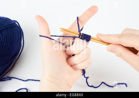 Frau begann stricken. Knäuel blaue Garn liegt auf weißem Hintergrund. Stockfoto