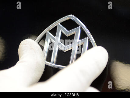 Ein Mitarbeiter legt das Emblem des Mercedes-Luxus-Auto-Modell Maybach auf der Motorhaube eines Autos Maybach im Montagewerk für Mercedes in Sindelfingen, Deutschland, 28. Januar 2015. Foto: Bernd Weissbrod/dpa Stockfoto