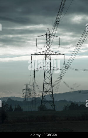 Elektrische Pylonen führt in einem Gewitterhimmel, Oxfordshire, England Stockfoto