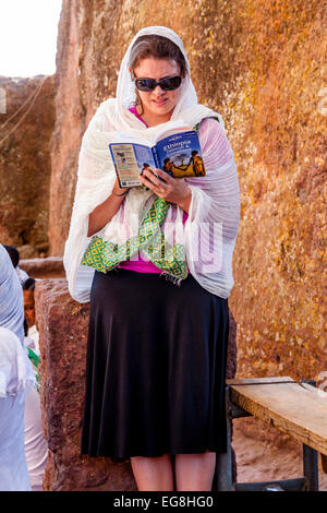 Ein Tourist Lesen der Lonely Planet-Reiseführer nach Äthiopien, Bete Maryam Kirche, Lalibela, Äthiopien Stockfoto