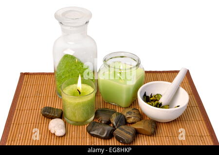 Spa-Einstellung mit Aroma-Kerzen und Steinen auf Bambus Teppich isoliert auf weiss Stockfoto