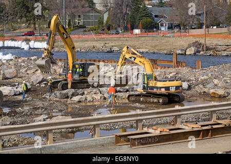 Schweren Erdbau Schaufeln und andere Geräte arbeiten auf die Veränderung des Flussbettes des Deschutes River in Bend, Oregon. Stockfoto