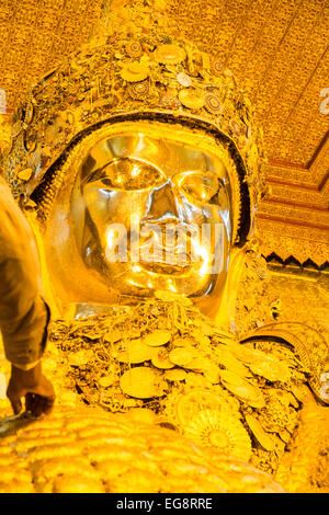 Anwenden von Blattgold auf riesigen goldenen Buddha, Mahamuni-Statue eines der am meisten verehrten Buddhas in Burma.Mandalay, Burma, Myanmar. Stockfoto