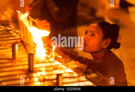 Burmesische Frau Anzünden einer Kerze als Opfergabe; Shwedagon-Pagode in Yangon, Myanmar (Burma), Asien Stockfoto