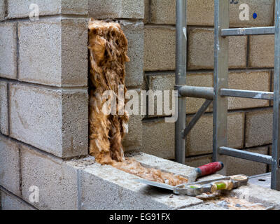 Wohnhauserweiterung im Bau mit Dämmmaterial sichtbar im Hohlraum zwischen zwei Brise Block Wände für Wärme sorgen Stockfoto