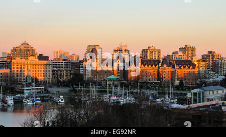 Sonnenuntergang über die Gebäude der Innenstadt von Victoria über Boote im Hafen. Stockfoto