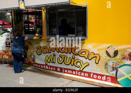 Frau, die Bestellung von einem Jamaican Food Truck in der Innenstadt von Vancouver, British Columbia, Kanada Stockfoto