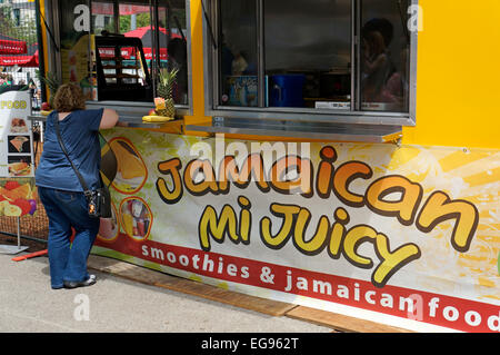 Frau, die Bestellung von einem Jamaican Food Truck in der Innenstadt von Vancouver, British Columbia, Kanada Stockfoto