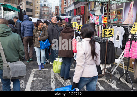 Menschen beim Einkaufen auf Pettycoat Lane Market in der City of London, UK. Petticoat Lane Market ist ein Mode- und Bekleidungs-Markt im Londoner East End. Es besteht aus zwei angrenzenden Straßenmärkte. Wentworth Street Market ist sechs Tage pro Woche und Middlesex Street Market ist geöffnet am Sonntag nur. Der Name kam Petticoat Lane aus nicht nur den Verkauf von Unterröcken, sondern aus der Fabel, dass "sie würde Ihr Petticoat an einem Ende des Marktes stehlen und es Ihnen auf der anderen verkaufen." Stockfoto