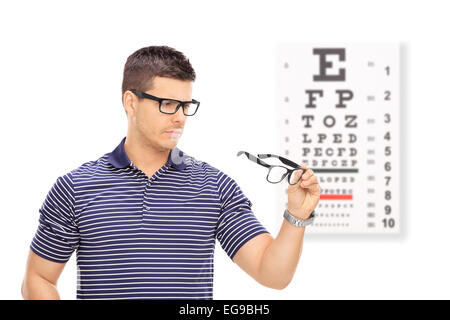 Mann, der versucht auf Gläser vor ein Auge Tabelle isoliert auf weißem Hintergrund Stockfoto