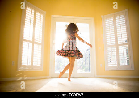Junge Frau, die Spinnerei in sonniges Zimmer Stockfoto