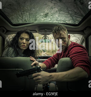Mann und Frau im Auto mit Pistole Stockfoto