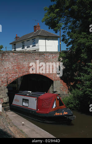 Ein Narrowboat unter Stenson Brücke kommen aus Stenson Sperre von Stenson Schloss Cafe auf der Trent und Mersey Kanal in der Nähe von Derby Stockfoto